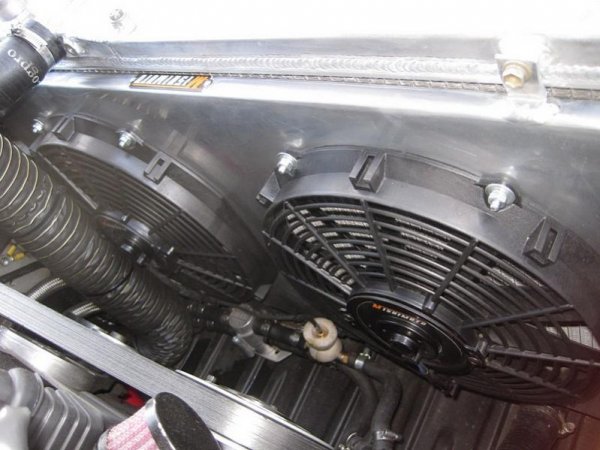 Mishimoto aluminium shroud with twin electric fans, mounted to an ASI 50 mm double core alloy rad.
The transmission fluid line with a Mocal thermostat and insulated oil temp gauge sensor, on route to